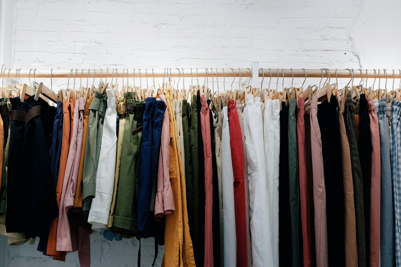 Portant en bois avec des vêtements de différentes couleurs suspendus sur des cintres